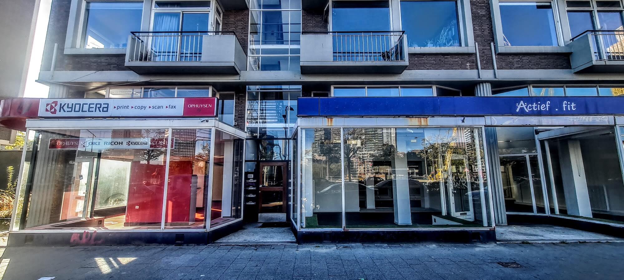 Leegstaande winkels en verrommelde winkelpuien aan de huidige Schiedamsedijk.